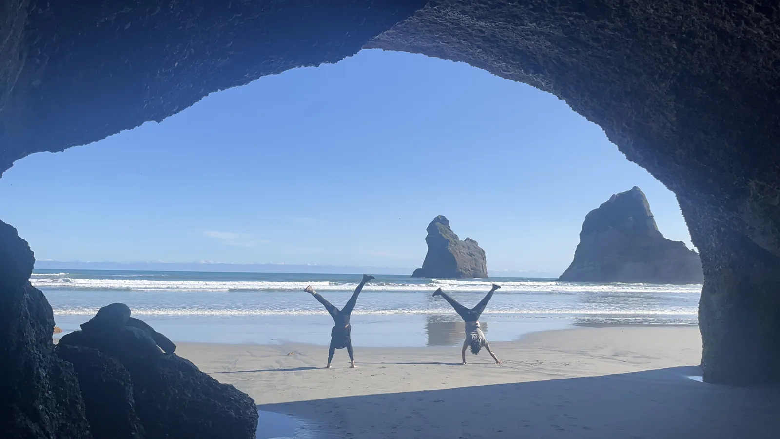 Tyler and Kat doing handstands on Wharariki Beach, New Zealand